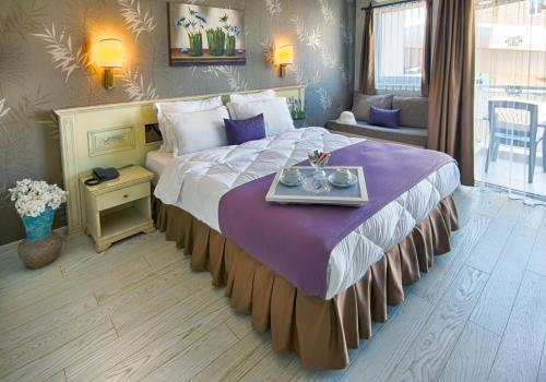 una camera d'albergo con un grande letto e un vassoio di Romance Beach Hotel a Marmaris