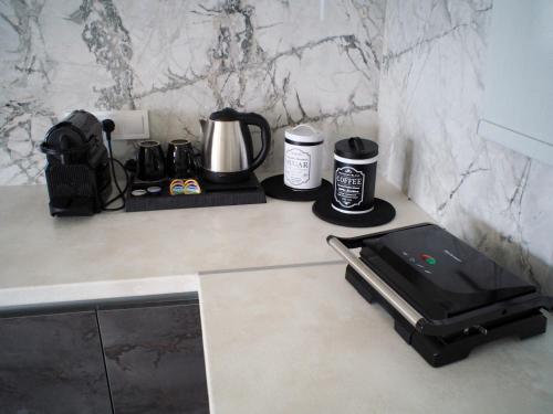 a kitchen counter with a coffee maker and a tablet on it at Nostos Luxury Villas with Private Pool in Nafpaktos in Nafpaktos