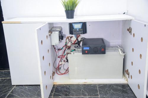 a cabinet with a computer and wires underneath it at The Grenadines Apartment in Lagos