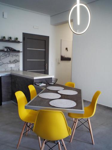 a dining room with a table and yellow chairs at Nostos Luxury Villas with Private Pool in Nafpaktos in Nafpaktos