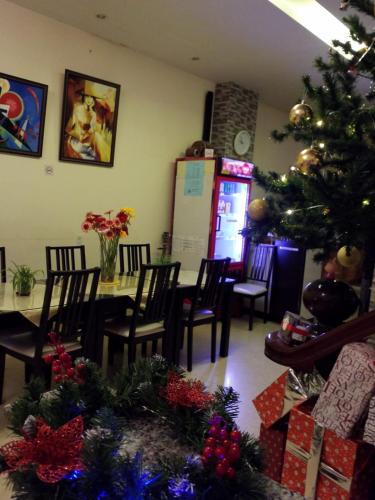a dining room with a christmas tree and a table and chairs at Pretty Backpackers House in Da Lat