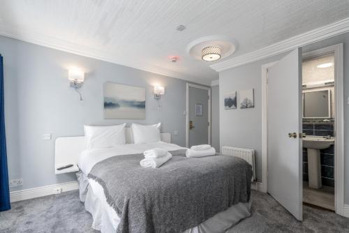 ein Schlafzimmer mit einem großen Bett mit Handtüchern darauf in der Unterkunft The Waterfront Townhouse Accommodation in Kilkenny