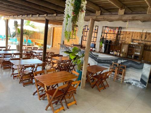 um restaurante com mesas e cadeiras de madeira em Santorini Beach Hotel em Arraial d'Ajuda