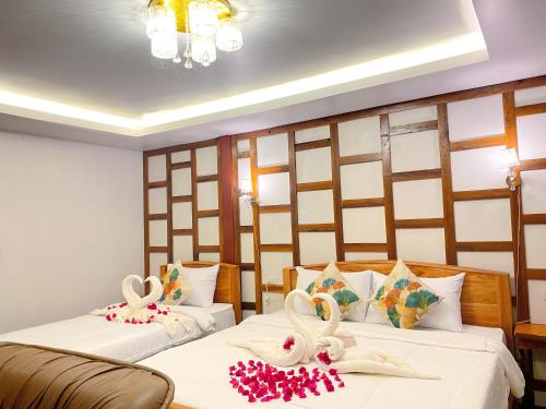 twee bedden in een kamer met zwanen erop bij Relaxing House Koh Yao Yai in Ko Yao Yai