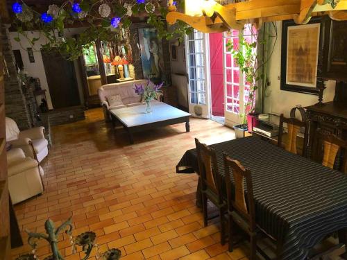 Cuxac-CabardèsMaison chaleureuse à Cuxac-Cabardès avec jardin de 3500m²的客厅里有一张桌子和一张沙发