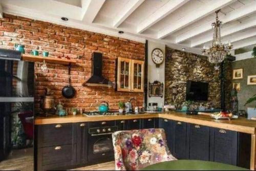a kitchen with a brick wall with a chair at Vake View Villa in Tbilisi City