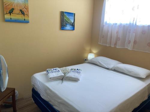 um quarto com uma cama com duas toalhas em Murph's Surf Shacks em Rivas