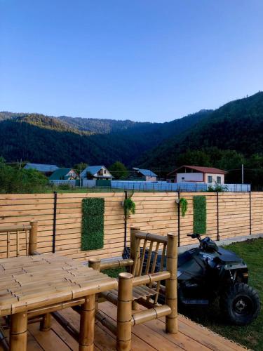 a motorcycle parked on a deck next to a wooden fence at Borjomi Story in Borjomi