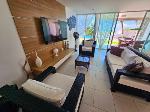 a living room with a couch and a tv at Romantic Sea Villa w/AMAZING SEA VIEW - DIRECTLY ON THE BEACH! in Maceió