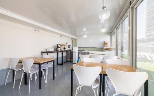 a dining room with white chairs and wooden tables at Sokcho Time Hotel in Sokcho