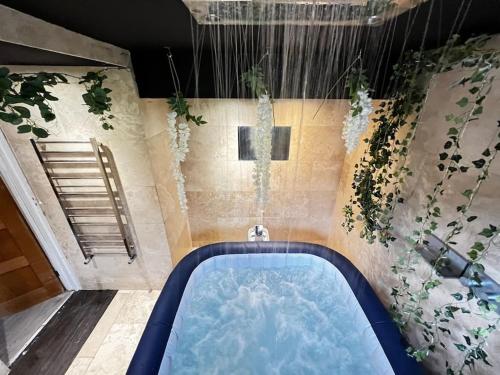 a bathroom with a hot tub with plants on the wall at The Coxhill Retreat - Indoor Rainforest Spa Stay in Dover