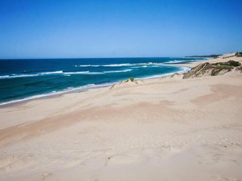 a sandy beach with the ocean in the background at Chelsea Manor in Kini Bay