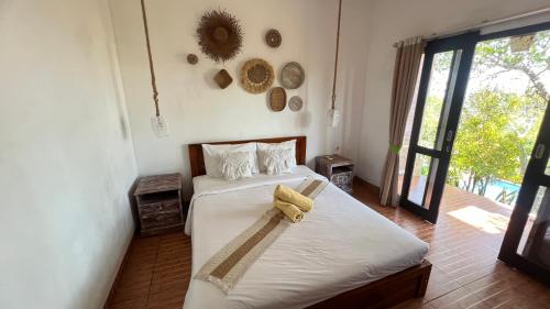 ein Schlafzimmer mit einem Bett und einem Handtuch darauf in der Unterkunft La village hills view in Nusa Penida
