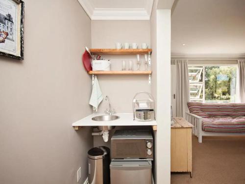 a small kitchen with a sink and a window at Chelsea Manor in Kini Bay