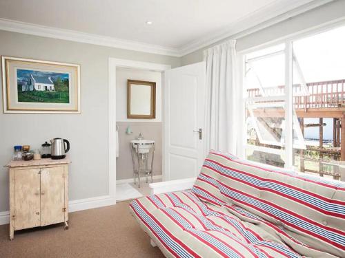 a living room with a bed and a window at Chelsea Manor in Kini Bay