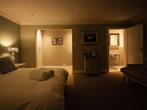 a bedroom with a bed with two towels on it at Chelsea Manor in Kini Bay
