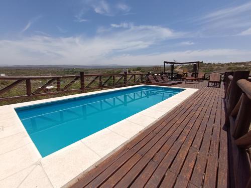 una piscina en la parte superior de una terraza de madera en Cabañas La Colina en Estancia Vieja
