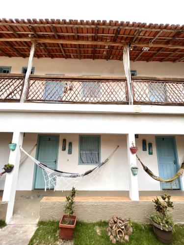 a building with a hammock in the courtyard at Pousada Vila Mar in Itaúnas