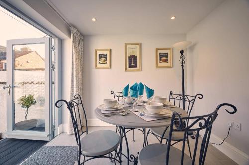 a dining room with a table and chairs and a window at Host & Stay - Roselyn By The Sea in Newbiggin-by-the-Sea