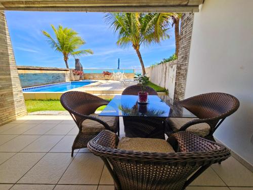 a table and chairs on a patio with a view of the ocean at Romantic Sea Villa w/AMAZING SEA VIEW - DIRECTLY ON THE BEACH! in Maceió
