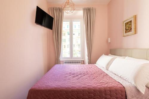 a bedroom with a pink bed and a window at Queen Meg Roma in Rome