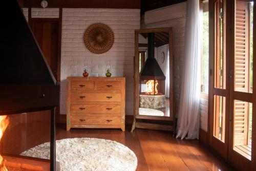 a bedroom with a dresser and a mirror at Pousada Terra Crua in Visconde De Maua