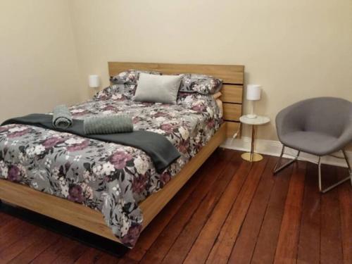 - une chambre avec un lit et une chaise dans l'établissement North Perth Stylish Character Home Close CBD, à Perth