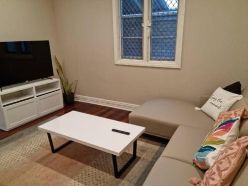 - un salon avec un canapé et une table basse dans l'établissement North Perth Stylish Character Home Close CBD, à Perth