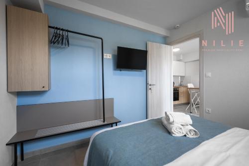a bedroom with a blue wall with towels on a bed at Ouranos, Nilie Hospitality MGMT in Nikiti