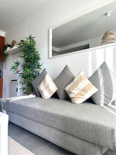 un sofá gris con almohadas en la sala de estar en Almar Carril, en Vilagarcía de Arousa