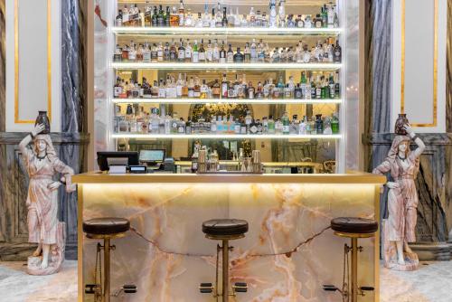 um bar numa sala com duas estátuas em Aleph Rome Hotel, Curio Collection By Hilton em Roma