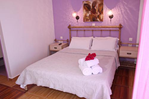 ein Schlafzimmer mit einem Bett mit zwei Handtüchern darauf in der Unterkunft Coralli Rooms & Restaurant in Elafonisos