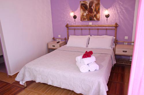 a bedroom with a bed with two towels on it at Coralli Rooms & Restaurant in Elafonisos