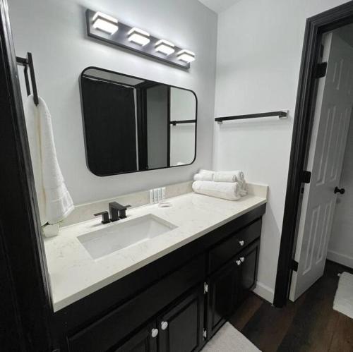 een badkamer met een wastafel en een grote spiegel bij Beautiful Paradise near AU in Auburn