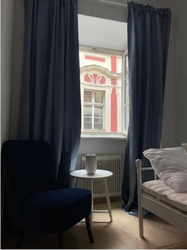 a bedroom with a chair and a table and a window at Stylish cozy apartment in graz in Graz