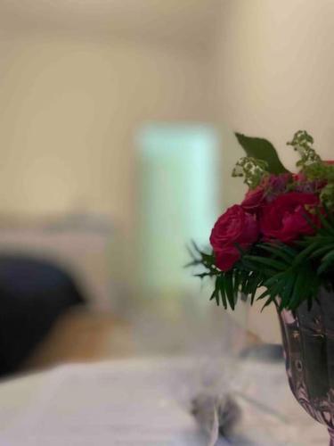 um vaso cheio de rosas vermelhas sentado numa mesa em Stylish cozy apartment in graz em Graz