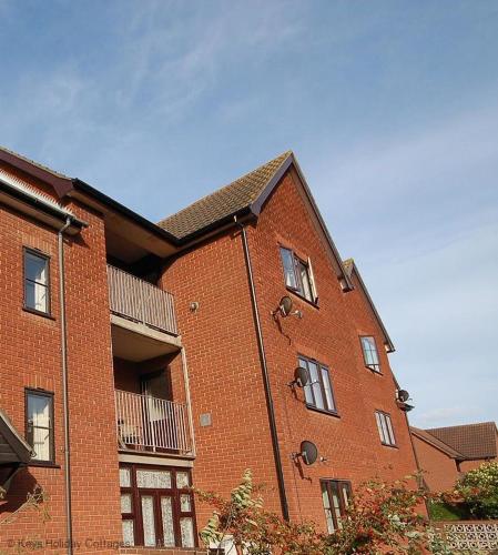 a large red brick building with a balcony at 4 Marriotts Way in Sheringham
