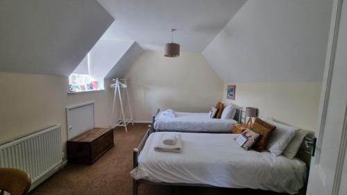 a bedroom with two beds and a couch at Walma in West Runton