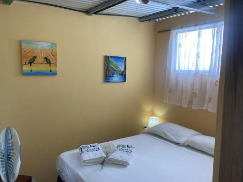 sypialnia z 2 łóżkami i ręcznikami w obiekcie Hostel Julieta w mieście Rivas