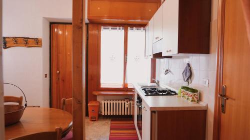 a kitchen with a stove and a counter top at Accogliente Appartamento Foppolo in Foppolo