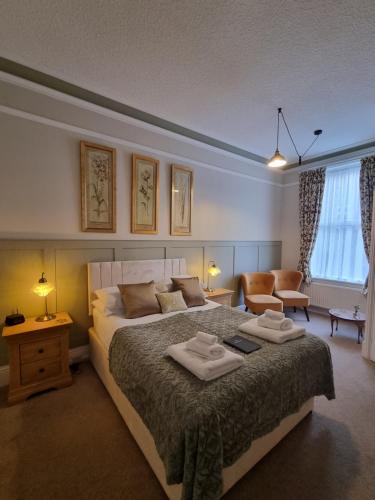 1 dormitorio con 1 cama grande y 2 toallas. en The Cavendish, en Scarborough