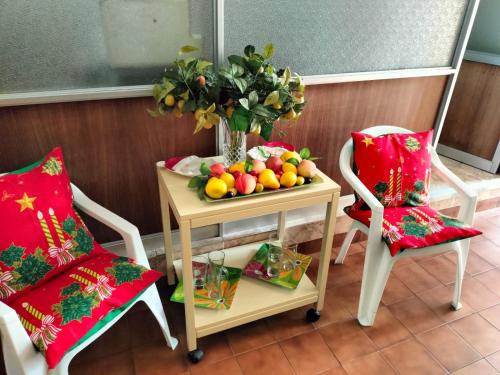 a table with a bowl of fruit on it next to two chairs at Hotel Angamos in Santiago
