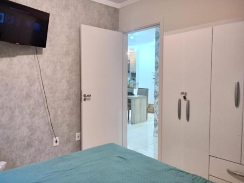 um quarto com uma cama e uma televisão na parede em Apartamentos com Vista pro Mar de Imbituba residencial mar azul em Imbituba