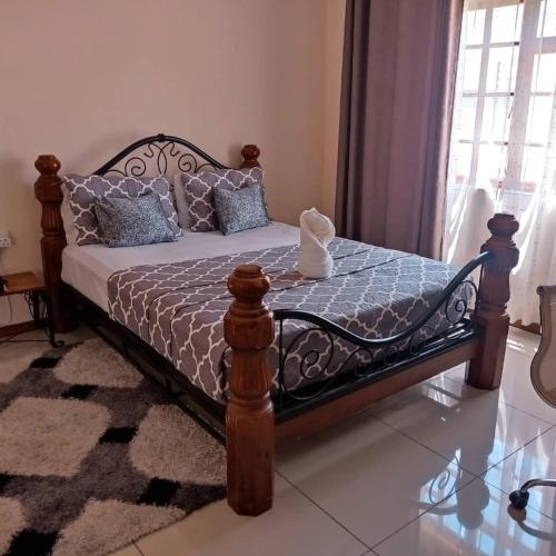 a bedroom with a bed with a wooden frame at WaterBerry Guest House in Kasane