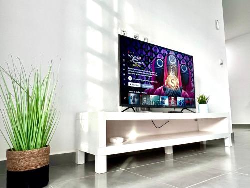 a flat screen tv sitting on a white entertainment center at Animoss! Apartments - 10 modern apartments near city center & beach in Santa Maria
