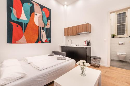 ブダペストにあるGrand Avenue Apartmentのベッド1台、花瓶付きのテーブルが備わる客室です。