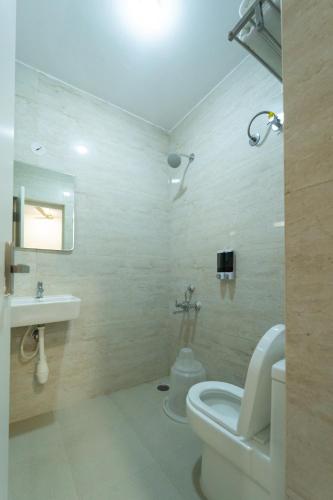 a bathroom with a toilet and a sink at Hoppers Stop Yelahanka in Bengaluru