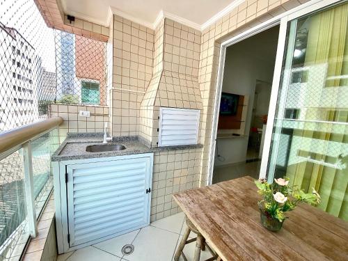 uma varanda com um lavatório e uma mesa na varanda em Residencial Santo Expedido na Praia Grande