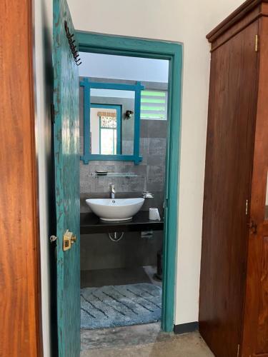 a bathroom with a sink and a mirror at Lobo's Villa in Kurunegala