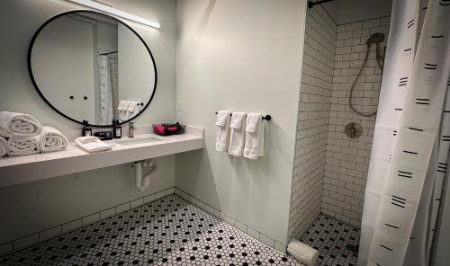 a bathroom with a mirror and a sink and a shower at Brewhalla Hotel in Fargo